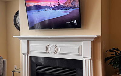 60" TV mounted over an electrical in-fireplace.