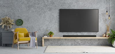 Soundbar mounted on wall directly below a flat-screen TV with hidden wiring