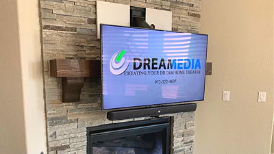 MantelMount pull-down TV mount installed above a fireplace — TV lowered to eye level for comfortable viewing