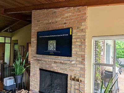 TV mounted on a stone fireplace wall — professional masonry TV installation